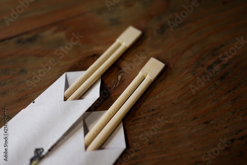 割り箸2本と紙袋。食事の準備。テーブルの上に置かれた和風食卓イメージ