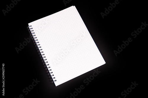 Quadro su tela Graph paper notebook with spiral binding, positioned diagonally against black ba