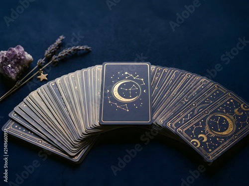 Tarot card deck fanned out with single card face-down, mystical still life