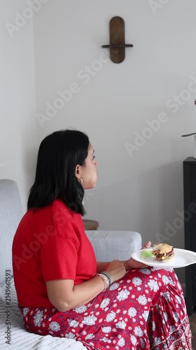 Woman Relaxing on Bed with Plate of Food Vertical Video