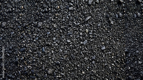 Close-up view of rough black asphalt road surface texture.