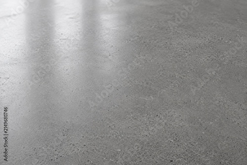 Polished grey concrete floor surface texture with light reflection