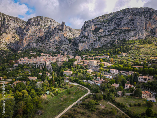 Moustiers-Sainte-Marie village nestled in rocky mountains under cloudy sky in Provence