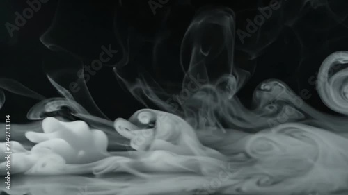 Ethereal Mist Formation: Wisps of white mist curl and swirl against a dark background, creating an abstract and atmospheric visual that evokes a sense of mystery and tranquility.