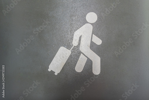 A white suitcase symbol on a green background at the airport.