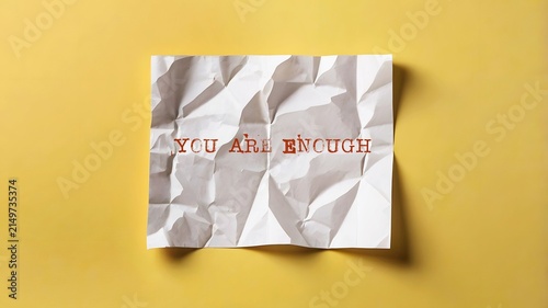 Yellow background with handwritten crumpled note YOU ARE ENOUGH , positive self-talk affirmation to boost self-esteem, build self-worth and develop self-respect