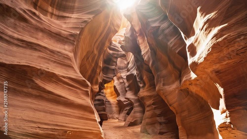 Narrow sandstone canyon with gracefully curving rock walls, glowing amber and crimson layers, intricate textures, breathtaking geological formations, 4K video
