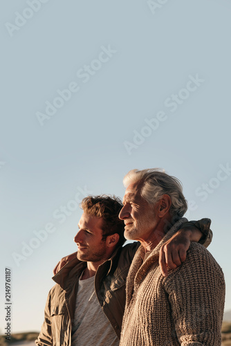 Young and Elderly Men, Son and Father, Embracing at Sunset in an Open Landscape, Symbolizing Intergenerational Friendship, Family Bond, Love, Support and Connection. Copy Space, 2:3