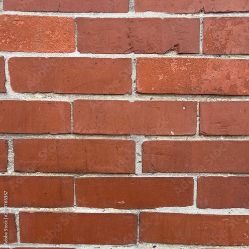 Cuadro en lienzo A flat view of a red brick wall with a repeating pattern of rectangular bricks a