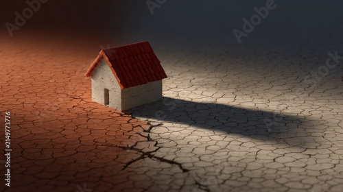 Miniature house standing on cracked dry earth during crisis