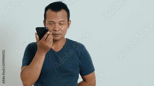 Video call. Portrait of man talking on smartphone or using virtual personal assistant app on his device. 
Asian man recording video call with mobile phone.