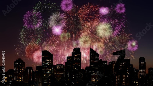 Night sky bursts with vibrant firework explosions above city skyline