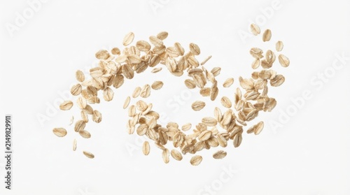Rolled oats scattered in mid-air against plain background