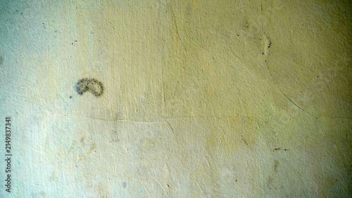 Faded yellow wall texture with subtle stains and grunge marks.
