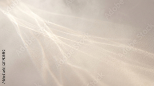 Bild auf Leinwand Ethereal light rays through smoke, soft sunbeams on beige background, cinematic