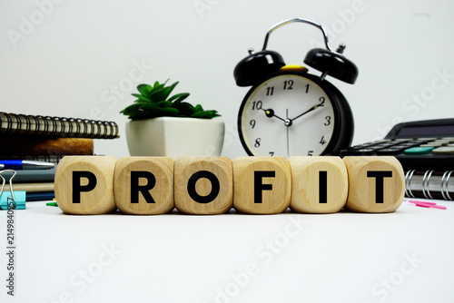 Foto PROFIT alphabet letters with alarm clock and calculator on white background