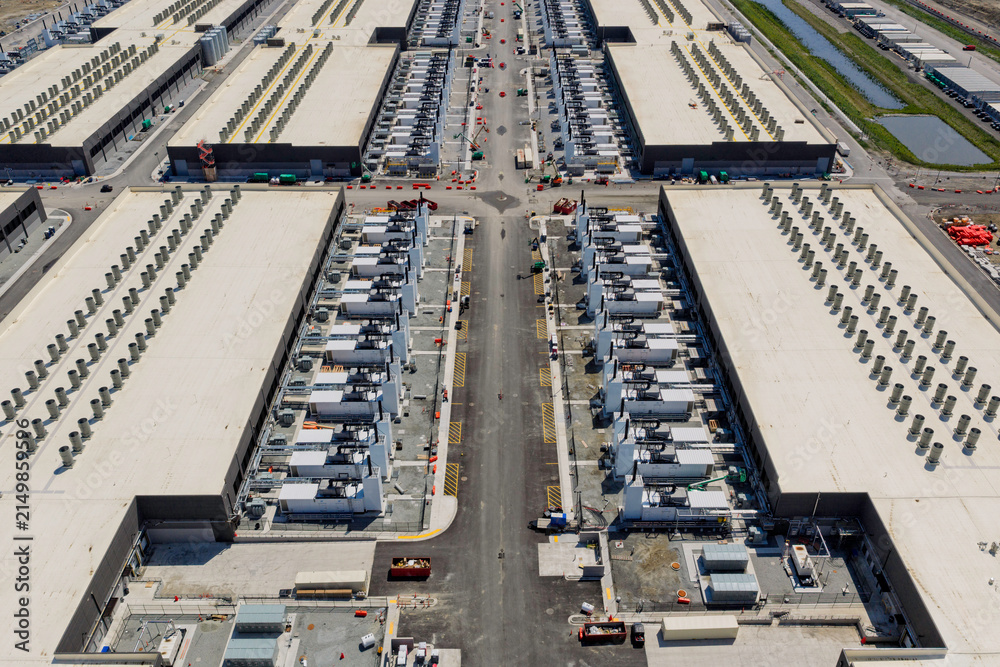 Naklejka premium Aerial view of the data center buildings, large AI center structure surrounded by cooling and power systems 