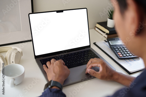 Person typing on a laptop at a home office desk with calculator and coffee, representing remote work, finance, productivity, and business planning.