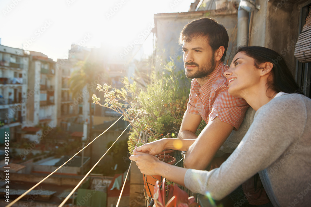 Obraz premium Thinking, couple and relax at house on balcony, scenery and bonding together on calm morning. Smile, people and daydreaming on terrace for stress relief, sightseeing view and weekend break with love