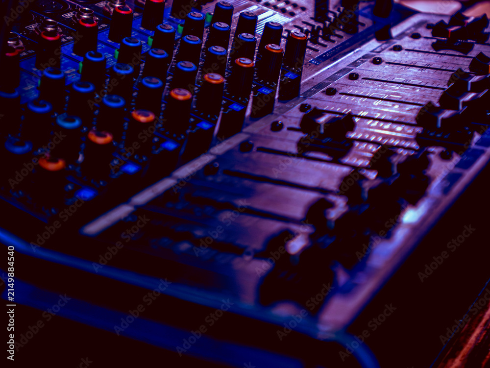 Fototapeta premium Moody Purple Lit Sound Mixer Console Faders and Knobs Close Up in Dark Ambiance