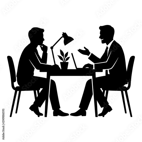 Two businessmen having discussion at desk with lamp and laptop.