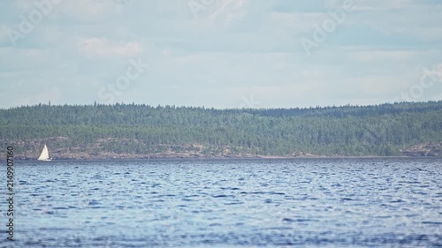 Yacht sailing past a rocky shore, time-lapse