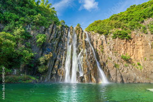 Cascade Niagara waterfall flowing into a turquoise basin framed by basalt cliffs in Reunion Island