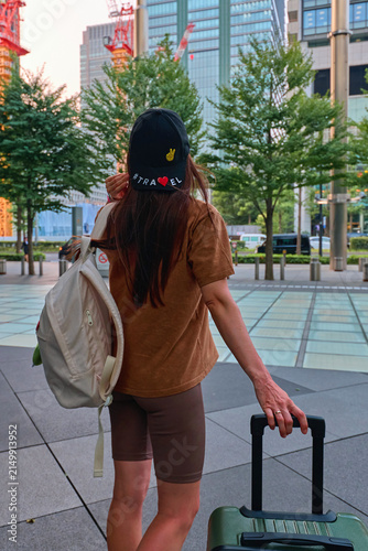 A traveler girl with a suitcase in the city