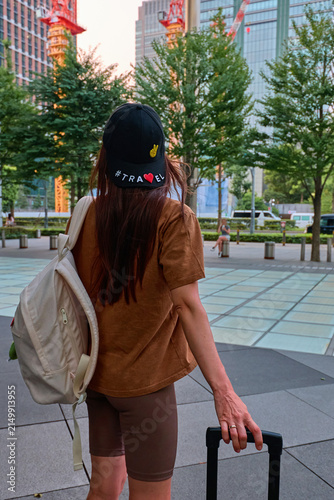 A traveler girl with a suitcase in the city