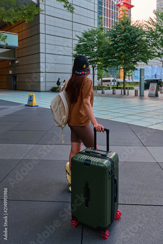 A traveler girl with a suitcase in the city