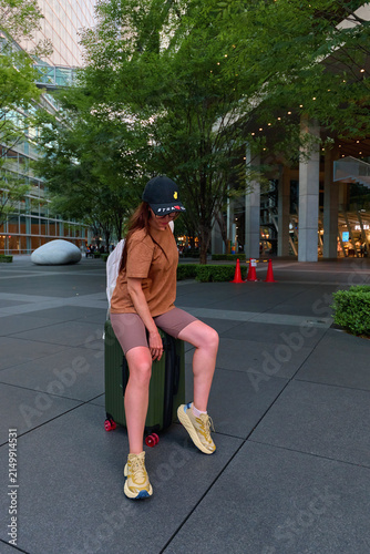A traveler girl with a suitcase in the city