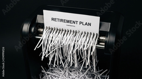 Retirement plan document being shredded paper shredder representing unsustainable investment risk and financial destruction business or personal