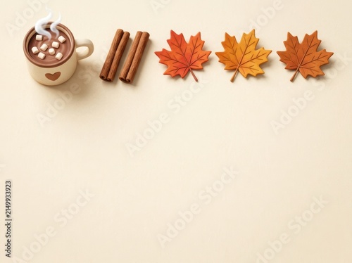 Mug of hot cocoa with cinnamon and autumn leaves