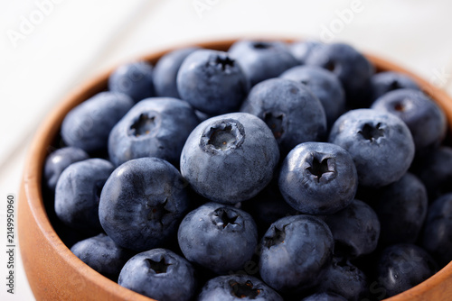 白い木目テーブルに置かれたボウルに入ったブルーベリー　Blueberries in a bowl on a white wooden table