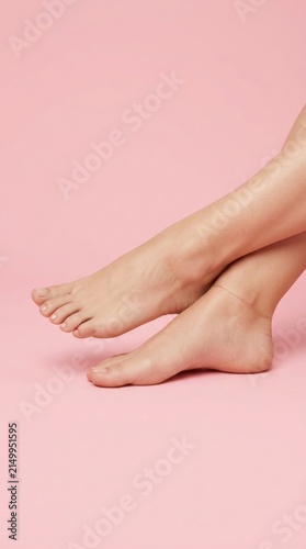 Detailed view of bare feet resting on a soft pink backdrop showcasing skin texture and a sense of calm