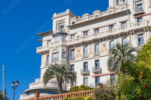 Mediterranean apartment building exterior with palm trees and blue sky