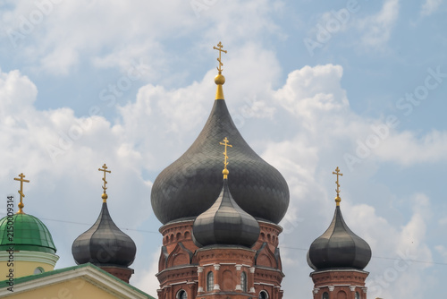 Canvastavla Building with onion domes and crosses under a cloudy sky in a city