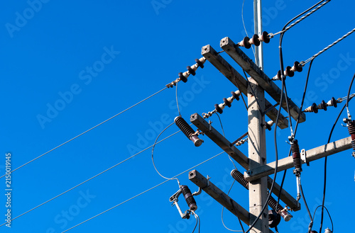High voltage electric pole and transmission lines with clear blue sky. Electricity pylon. Power and energy engineering system. Danger high voltage tower. Cable wire on electric pylon. Power industry.