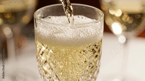 Close up of champagne pouring into crystal flute glass.