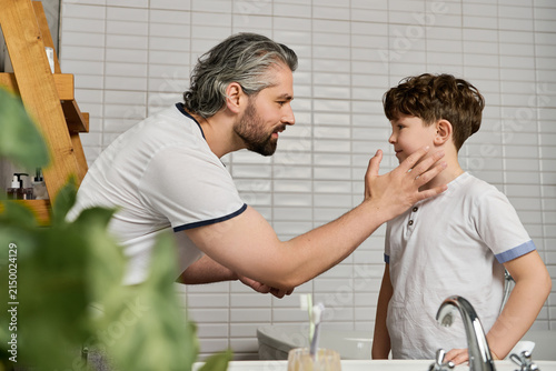 Fotografie A loving father shares playful banter with his cute son while getting ready for the day