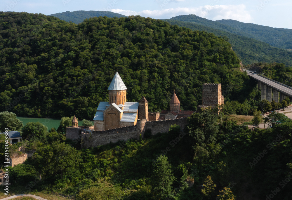 Fototapeta premium Ananuri Fortress surrounded by green mountains and forests in Georgia