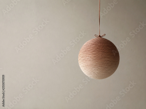 Single Temari Ball with Soft Ombre Gradient Hanging by a Silk Cord Against a Neutral Wall, Wellness and Meditation Background with Copy Space