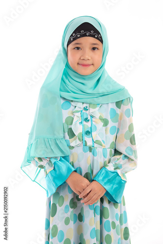 Charming young Muslim girl with hijab posing politely with hands clasped isolated on white background.
