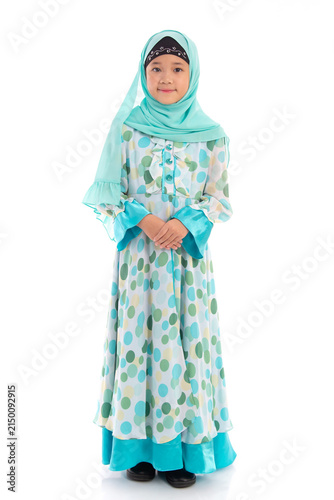 Charming young Muslim girl with hijab posing politely with hands clasped isolated on white background.