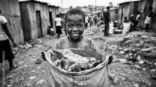Child holding bag of plastic bottles for recycling.