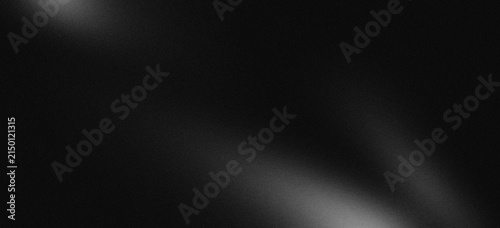 Monochrome abstract grey smooth gradation on black background with grainy noise texture.