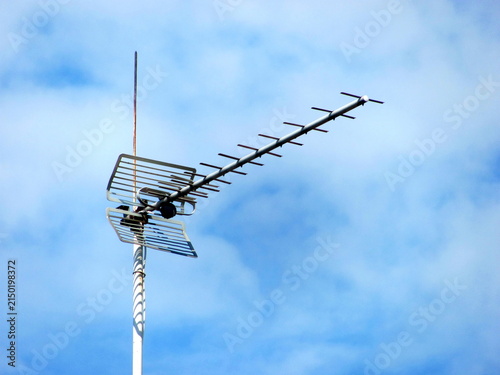 Cuadro en lienzo A metal UHF television antenna mounted outdoors against a partly cloudy blue sky