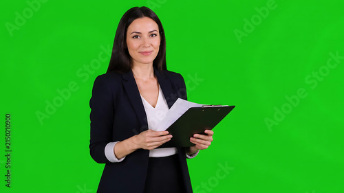 Ultra photorealistic professional businesswoman confidently presenting, holding a document folder on a green screen, ready to deliver an engaging business presentation with a friendly smile