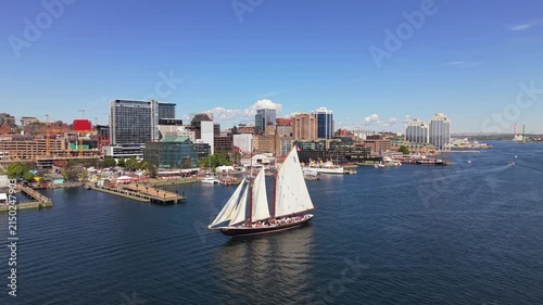 Dramatic drone view of Bluenose sailing in Halifax Harbor, showcasing the beauty of the ship and vibrant city skyline