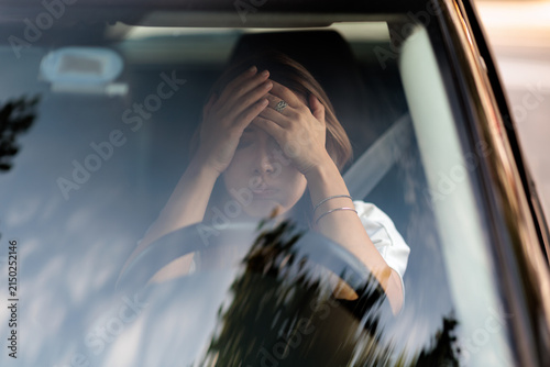 Stressed Anxious Woman Putting Hands On Forehead Inside Car Interior. Worried female driver feels panic after traffic accident sitting behind steering wheel